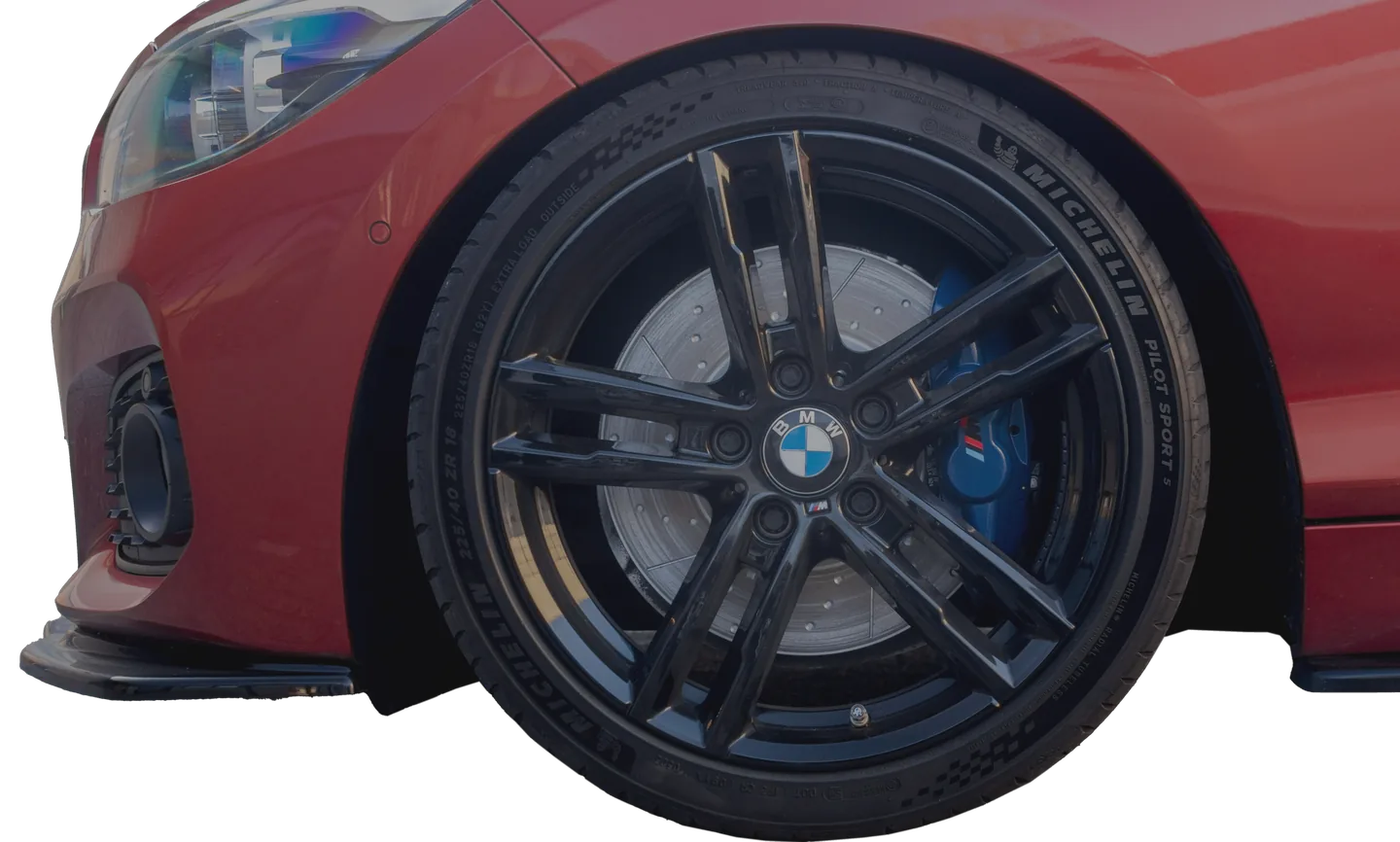 Voorwiel van een rode BMW met zwarte velg en blauwe remklauw.
